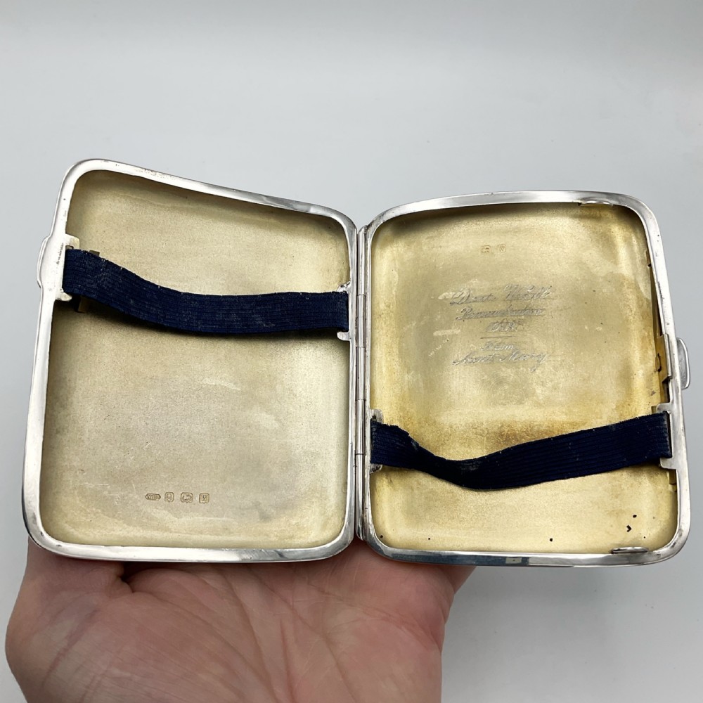 A curved rectangular sterling silver case featuring linear engine-turned pattern work and an engraved diamond monogram cartouche. View XII