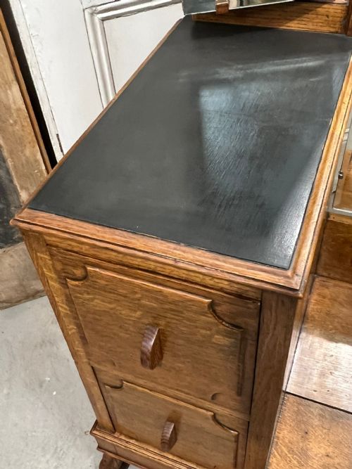 fig 1. An Edwardian oak dressing table with a central full-length mirror flanked by two adjustable side mirrors, set above twin pedestal drawer units with carved detailing.