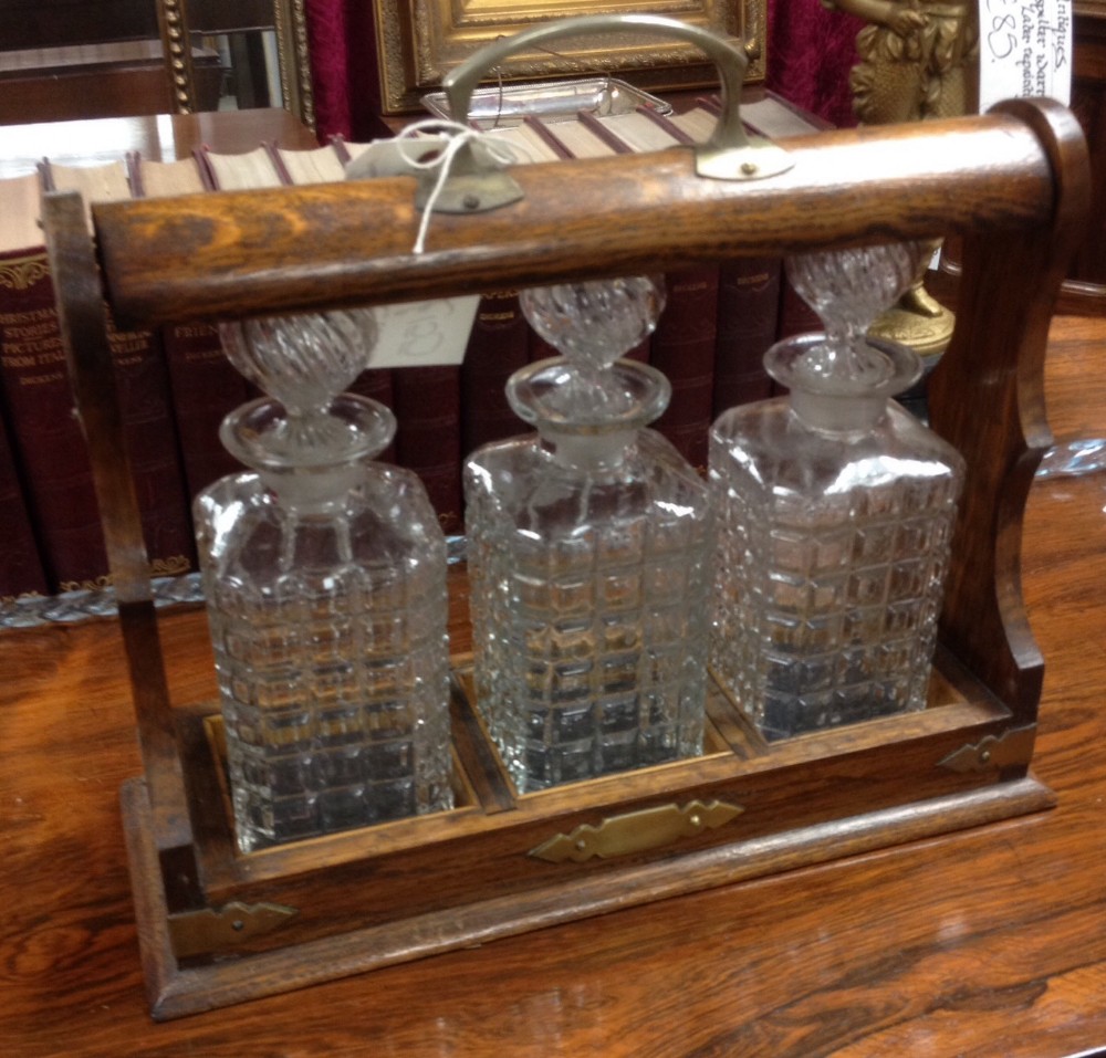 Edwardian oak tantalus with original bottles and key