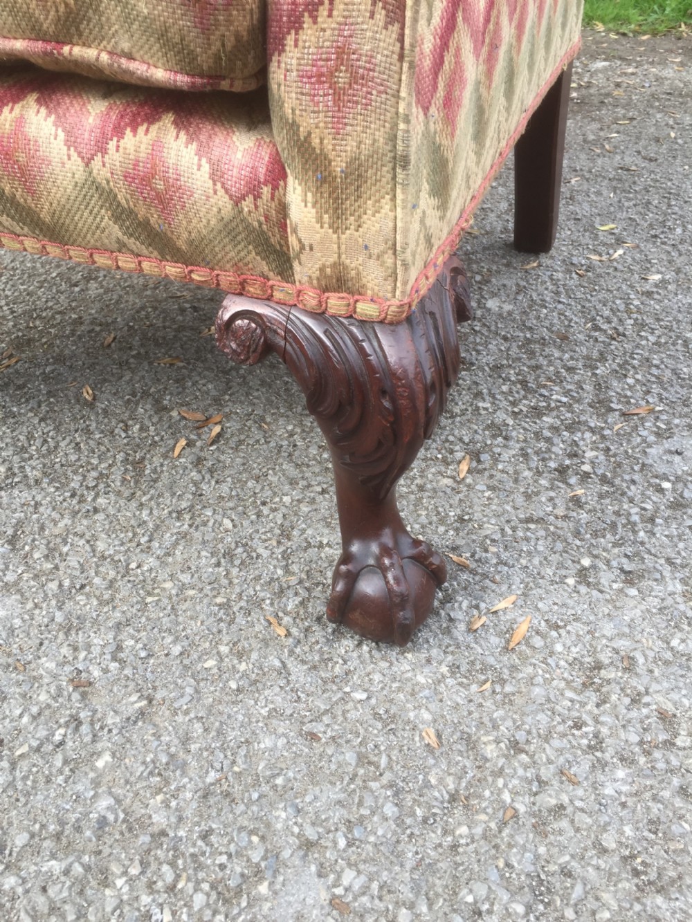Edwardian traditionally upholstered winged armchair on carved ball and claw feet View II