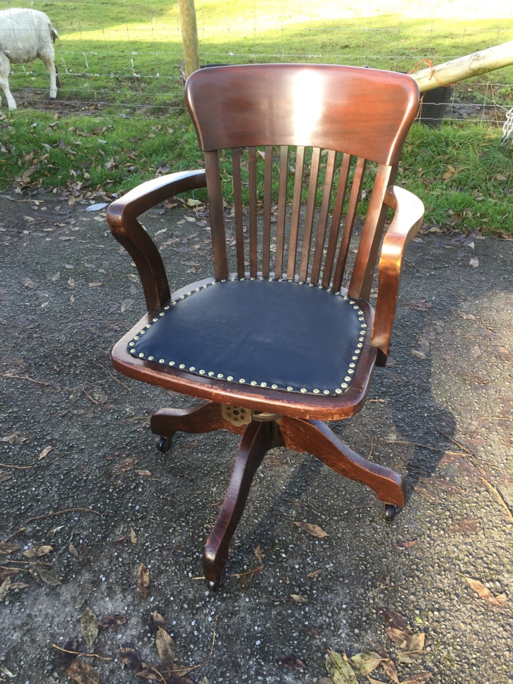 Slat back swivel office chair with leather seat  circa 1920
