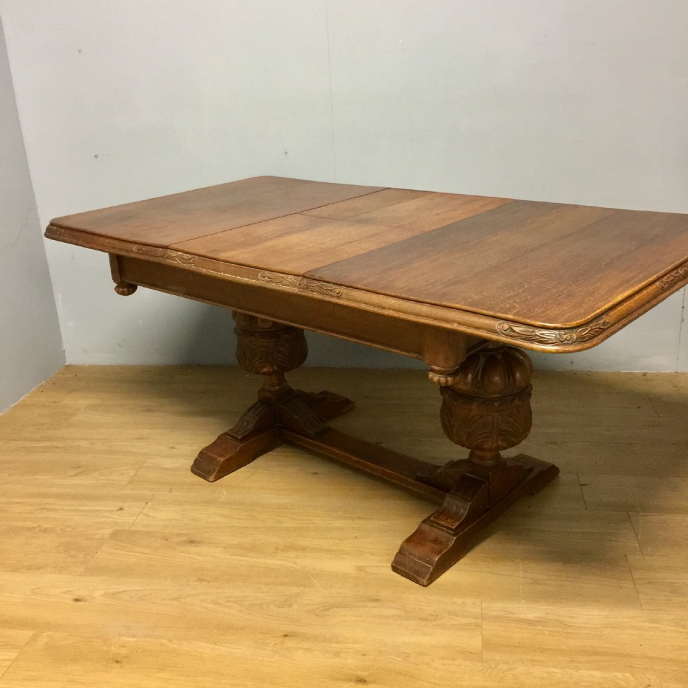 Oak extending table on carved baluster supports circa 1920