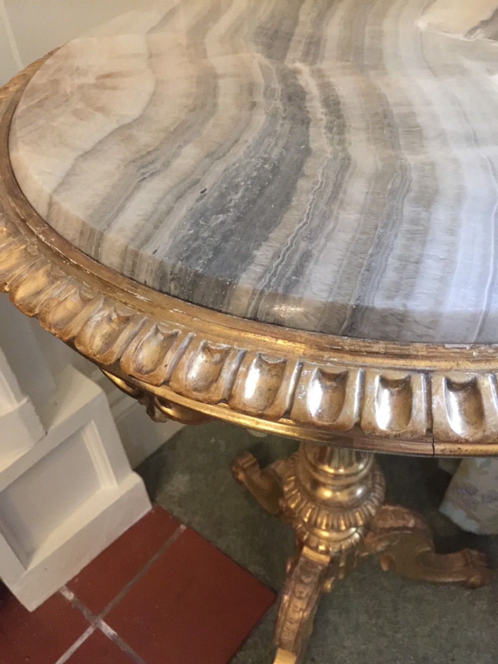 A 19th-century tripod table featuring a carved giltwood pedestal base, egg-and-dart moulding, and a circular variegated grey marble tabletop. View X
