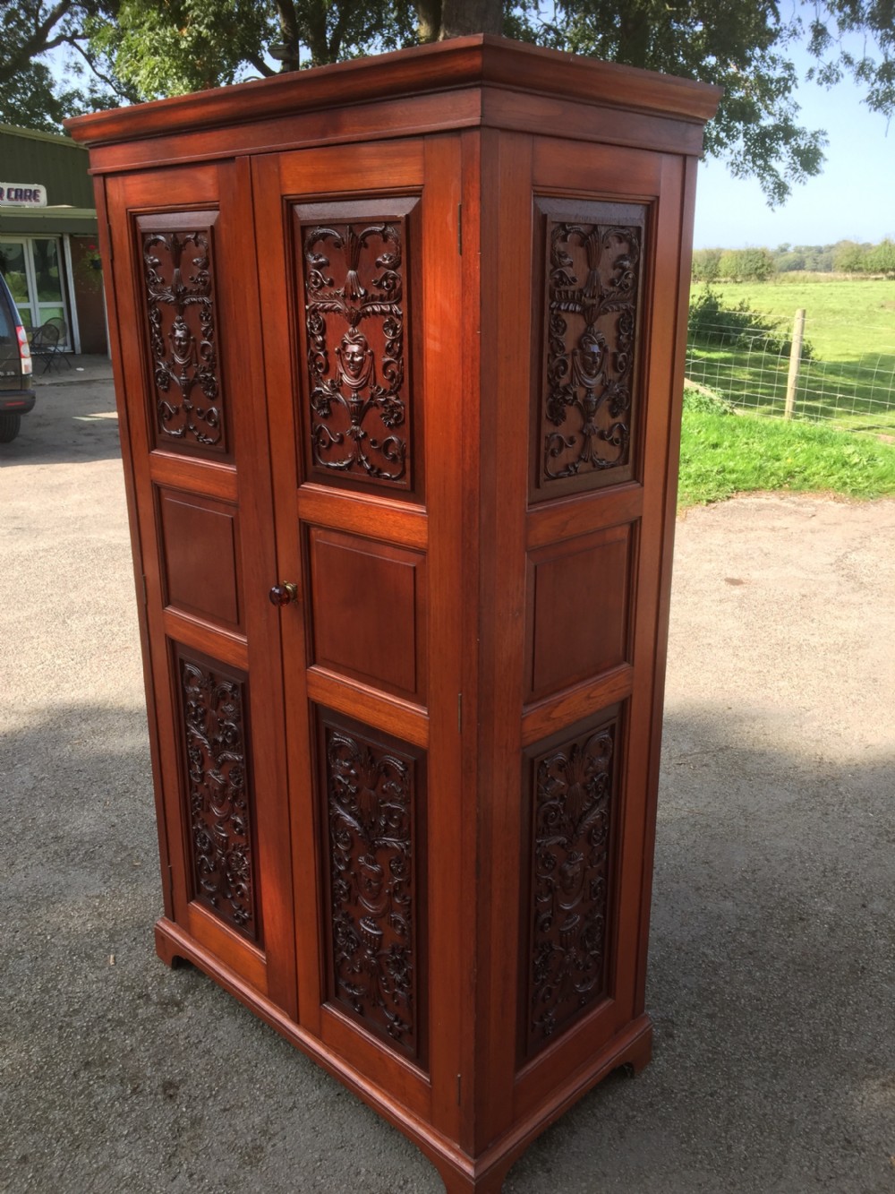Arts and Crafts walnut hall cupboard with carved panels 
