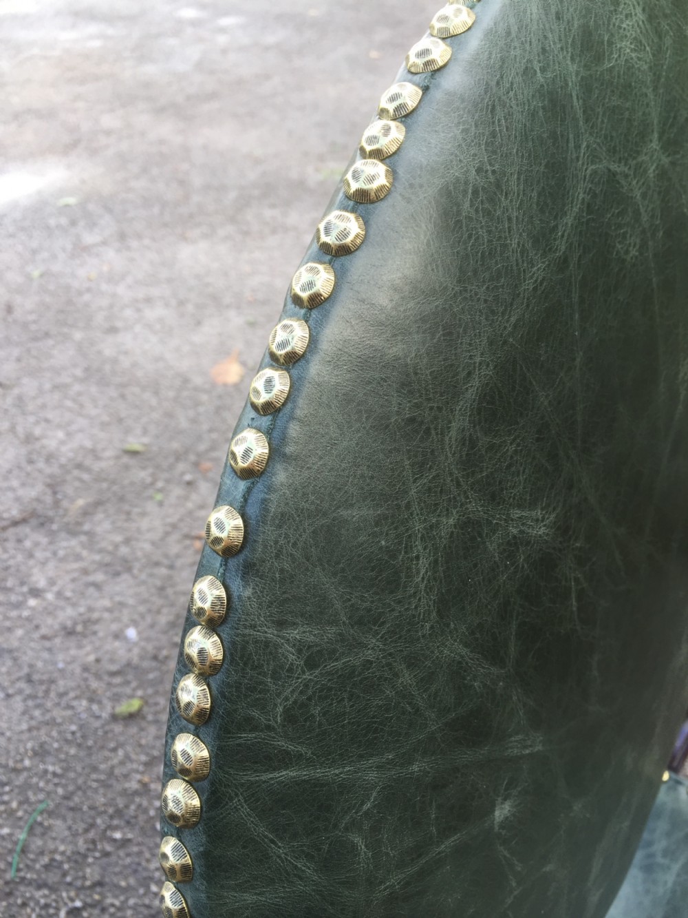 A nineteenth-century carved walnut X-frame armchair upholstered in dark olive green leather with brass stud details. View XI