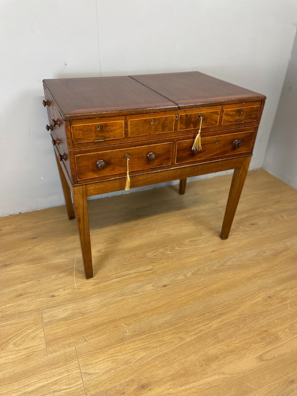 A Late Georgian inlaid mahogany collectors cabinet with square tapered legs, brass keyhole escutcheons, side knobs, and multiple drawers.