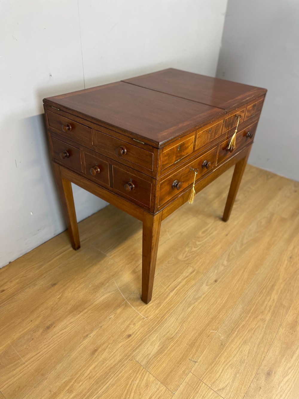 A Late Georgian inlaid mahogany collectors cabinet with square tapered legs, brass keyhole escutcheons, side knobs, and multiple drawers. View II