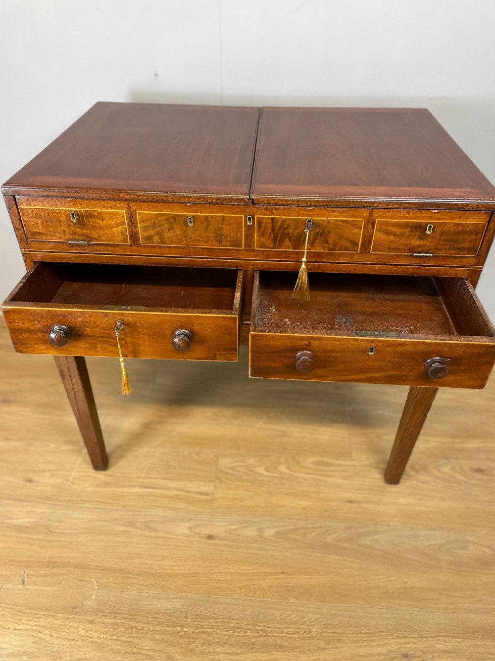 A Late Georgian inlaid mahogany collectors cabinet with square tapered legs, brass keyhole escutcheons, side knobs, and multiple drawers. View VII