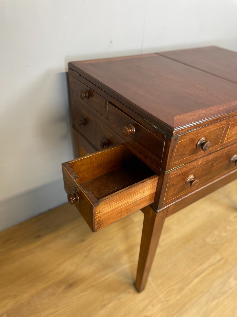 A Late Georgian inlaid mahogany collectors cabinet with square tapered legs, brass keyhole escutcheons, side knobs, and multiple drawers. View VIII