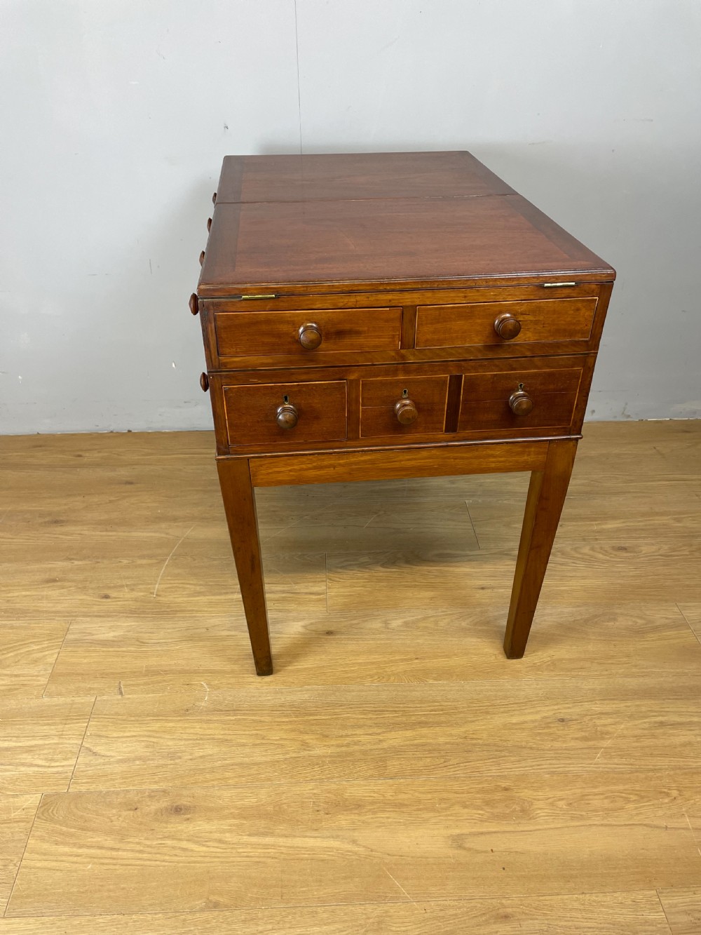 A Late Georgian inlaid mahogany collectors cabinet with square tapered legs, brass keyhole escutcheons, side knobs, and multiple drawers. View XII