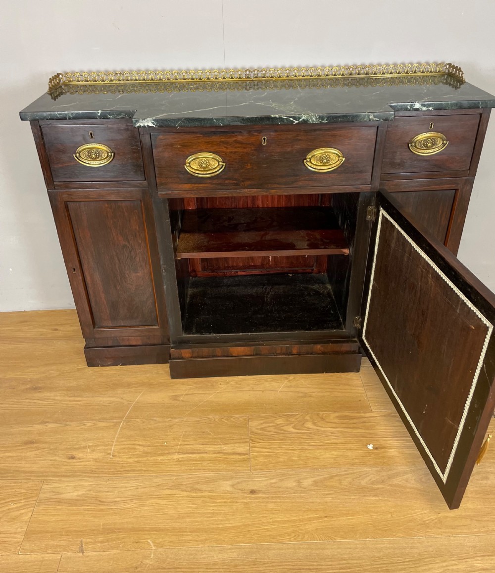 An early nineteenth-century Regency rosewood secretaire side cabinet featuring a dark green marble top with a brass gallery, a pleated fabric door panel, and brass handles. View XIII