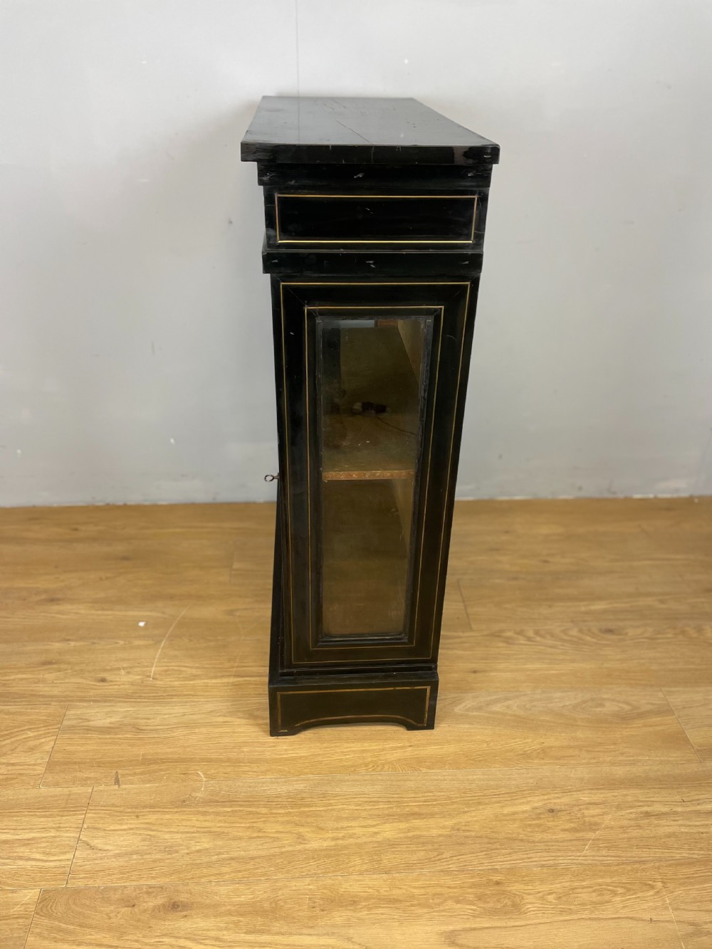An ebonised nineteenth-century single-door display cabinet featuring brass and red tortoiseshell Boulle marquetry inlay around a glazed door and side panels. View VIII