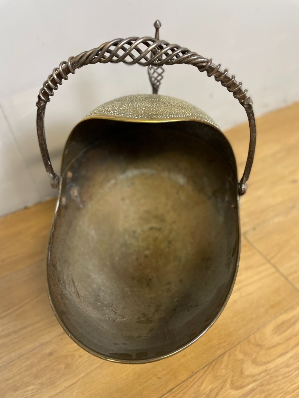 An Arts and Crafts style brass coal helmet with a textured hood, a wire-wrapped swing handle, a round pedestal base, and a matching hand shovel. View IV