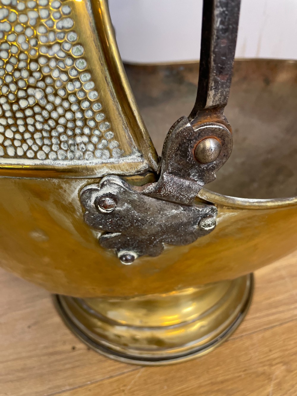 An Arts and Crafts style brass coal helmet with a textured hood, a wire-wrapped swing handle, a round pedestal base, and a matching hand shovel. View VIII