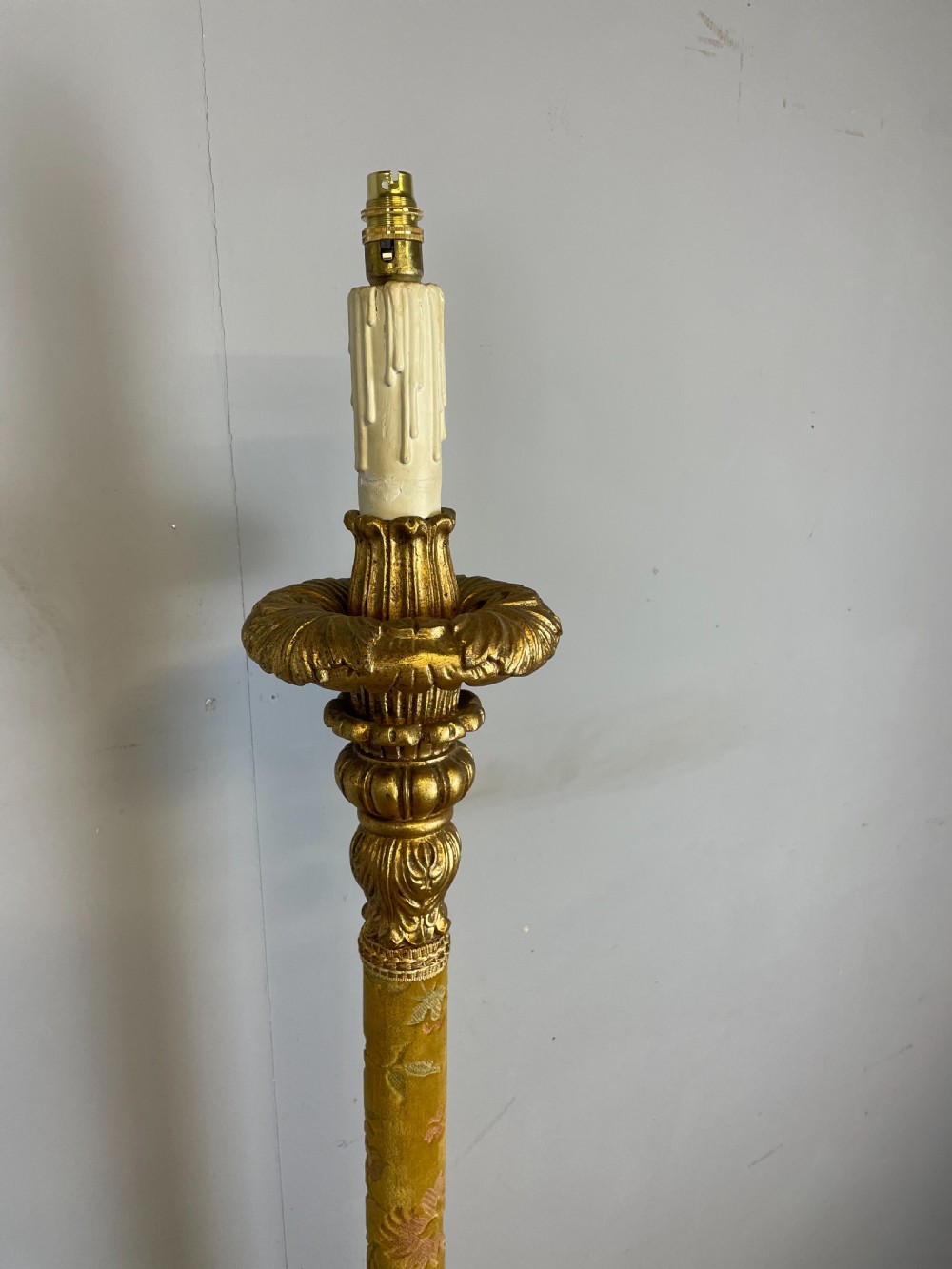 An Italian carved giltwood standard lamp with floral fabric central column details and a leaf-carved circular base. View II