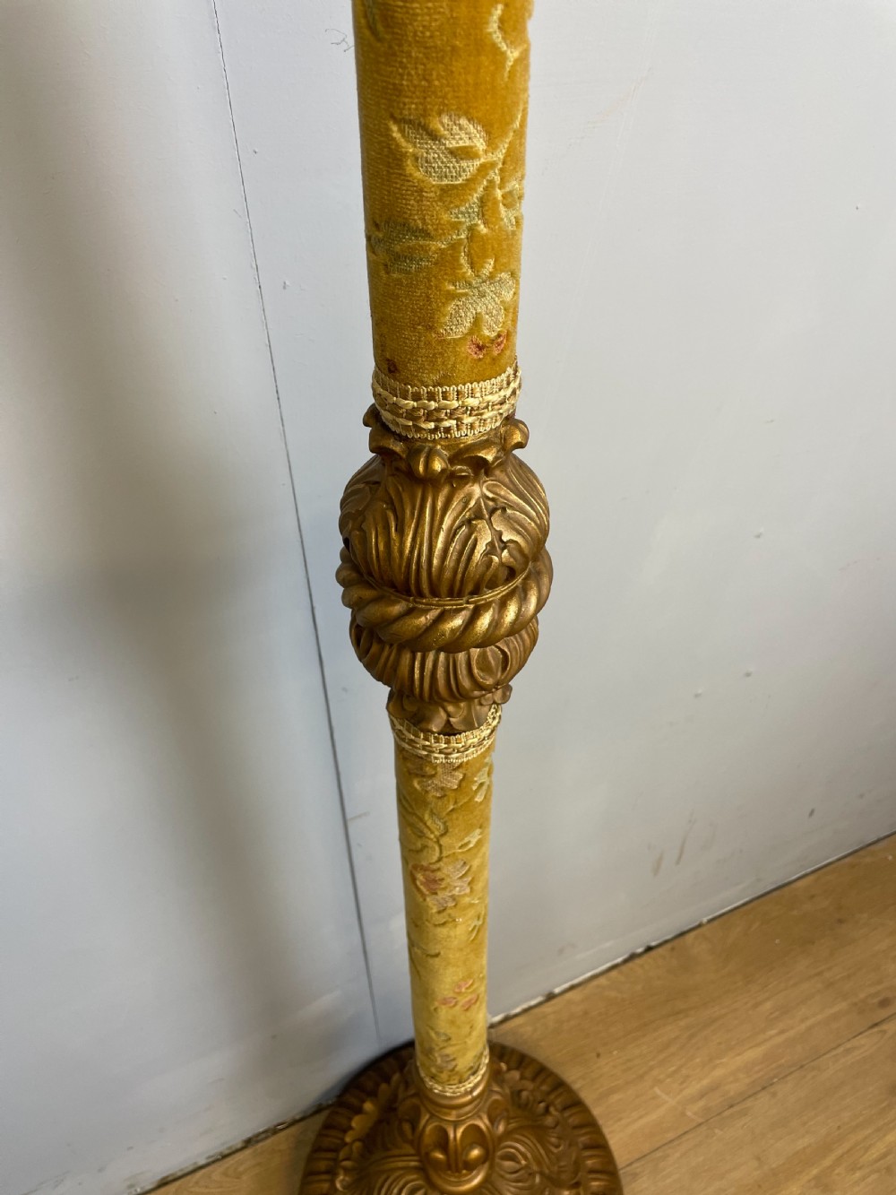 An Italian carved giltwood standard lamp with floral fabric central column details and a leaf-carved circular base. View III