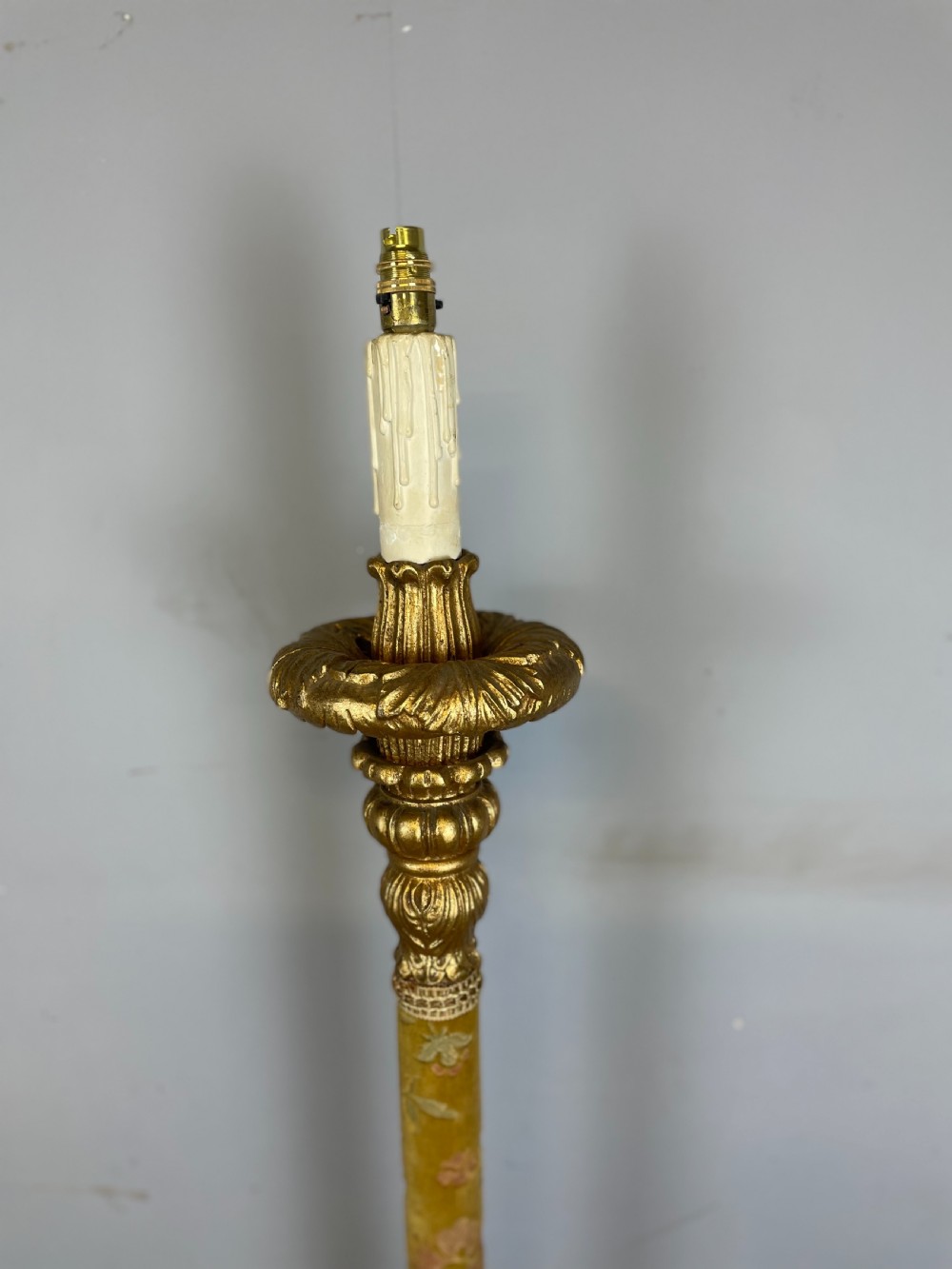 An Italian carved giltwood standard lamp with floral fabric central column details and a leaf-carved circular base. View V