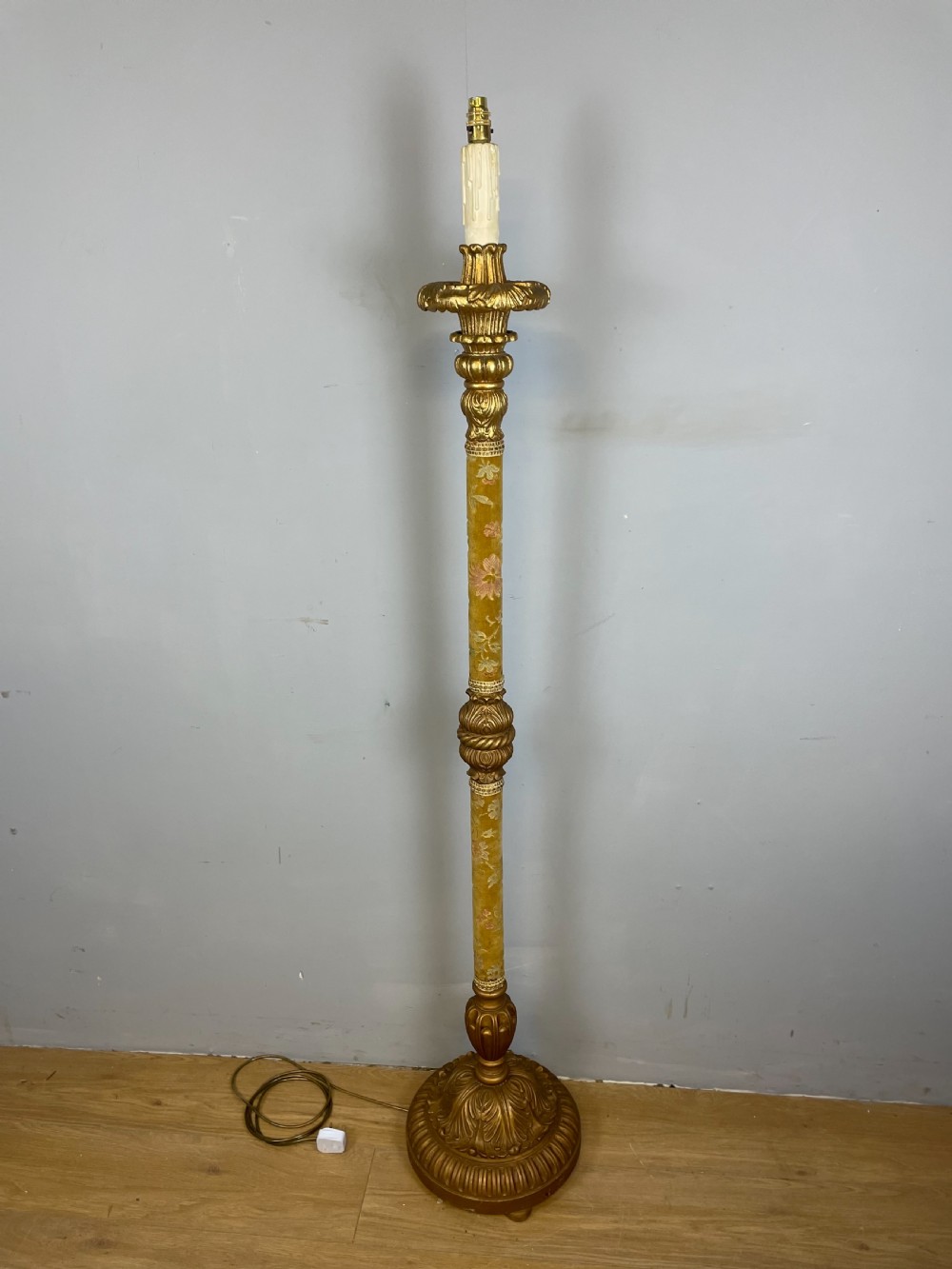An Italian carved giltwood standard lamp with floral fabric central column details and a leaf-carved circular base. View VI