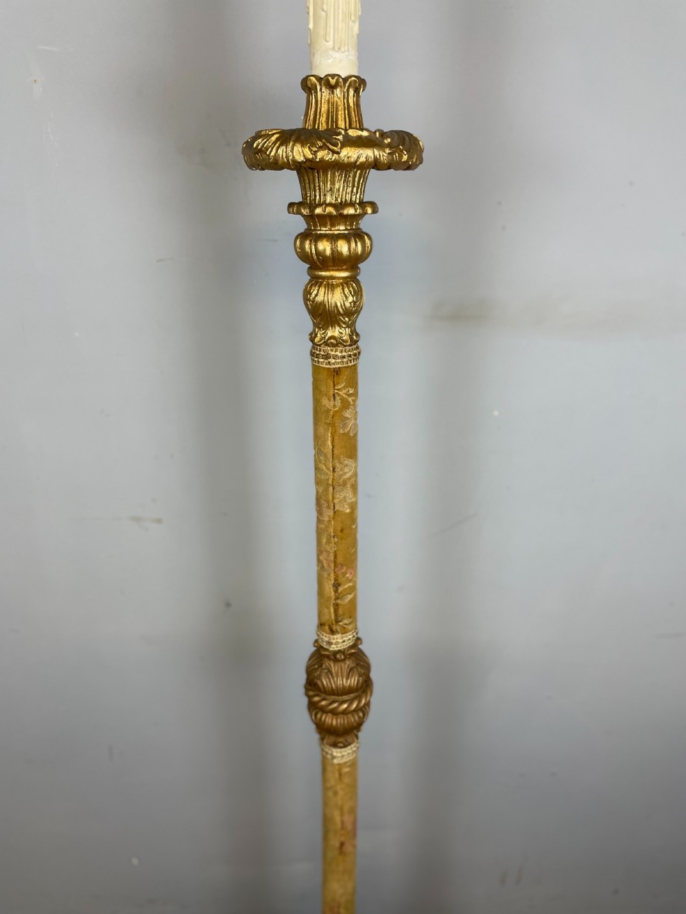 An Italian carved giltwood standard lamp with floral fabric central column details and a leaf-carved circular base. View VIII