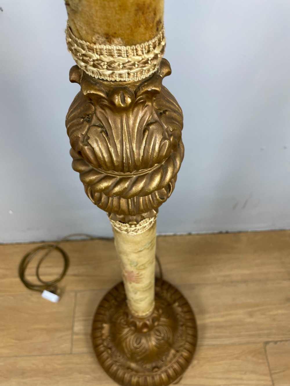 An Italian carved giltwood standard lamp with floral fabric central column details and a leaf-carved circular base. View X