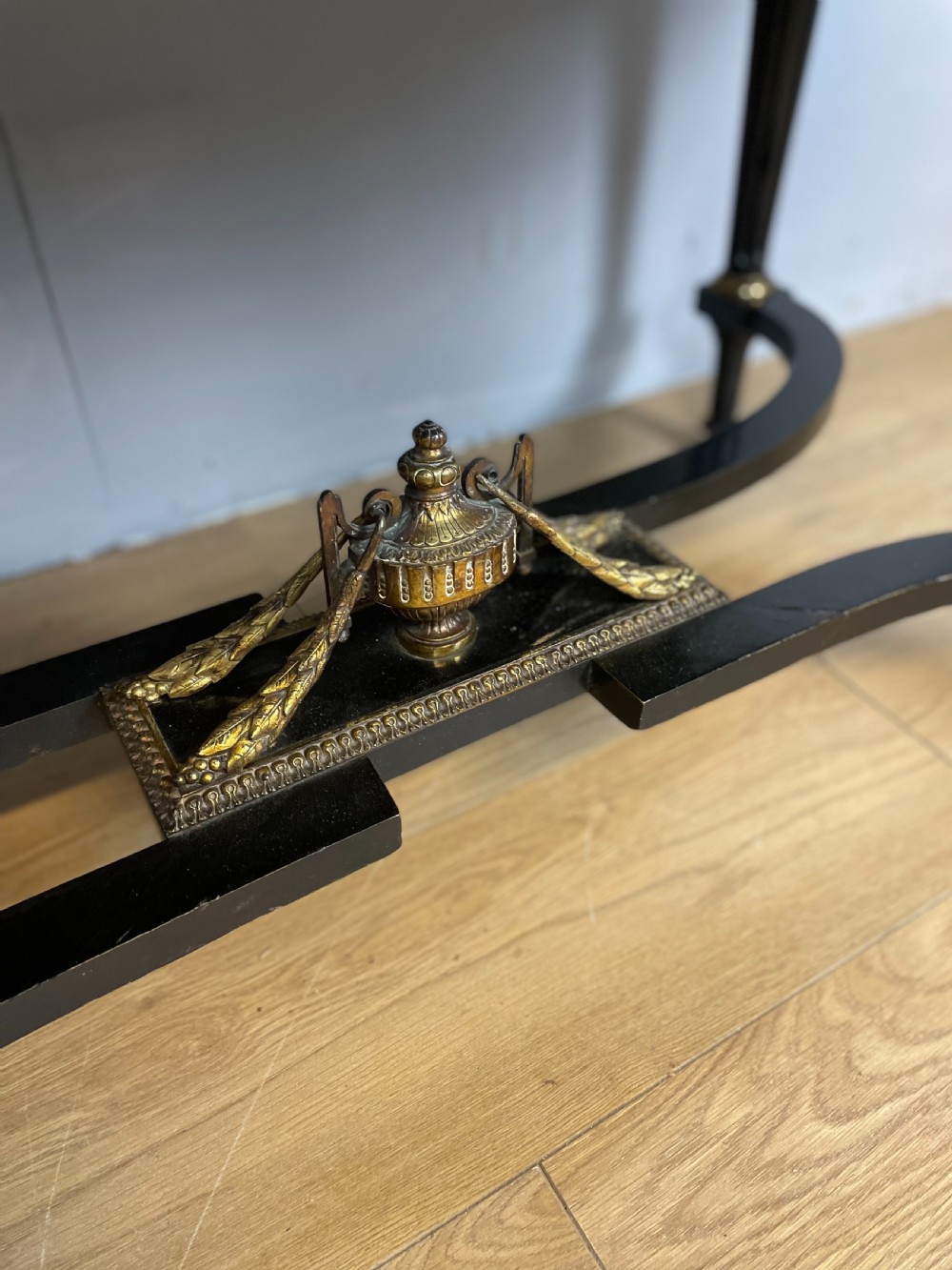 An ebonised nineteenth-century French writing table featuring gilt-bronze mounts, fluted tapered legs, a single central drawer, and a shaped top with central marquetry detailing. View III