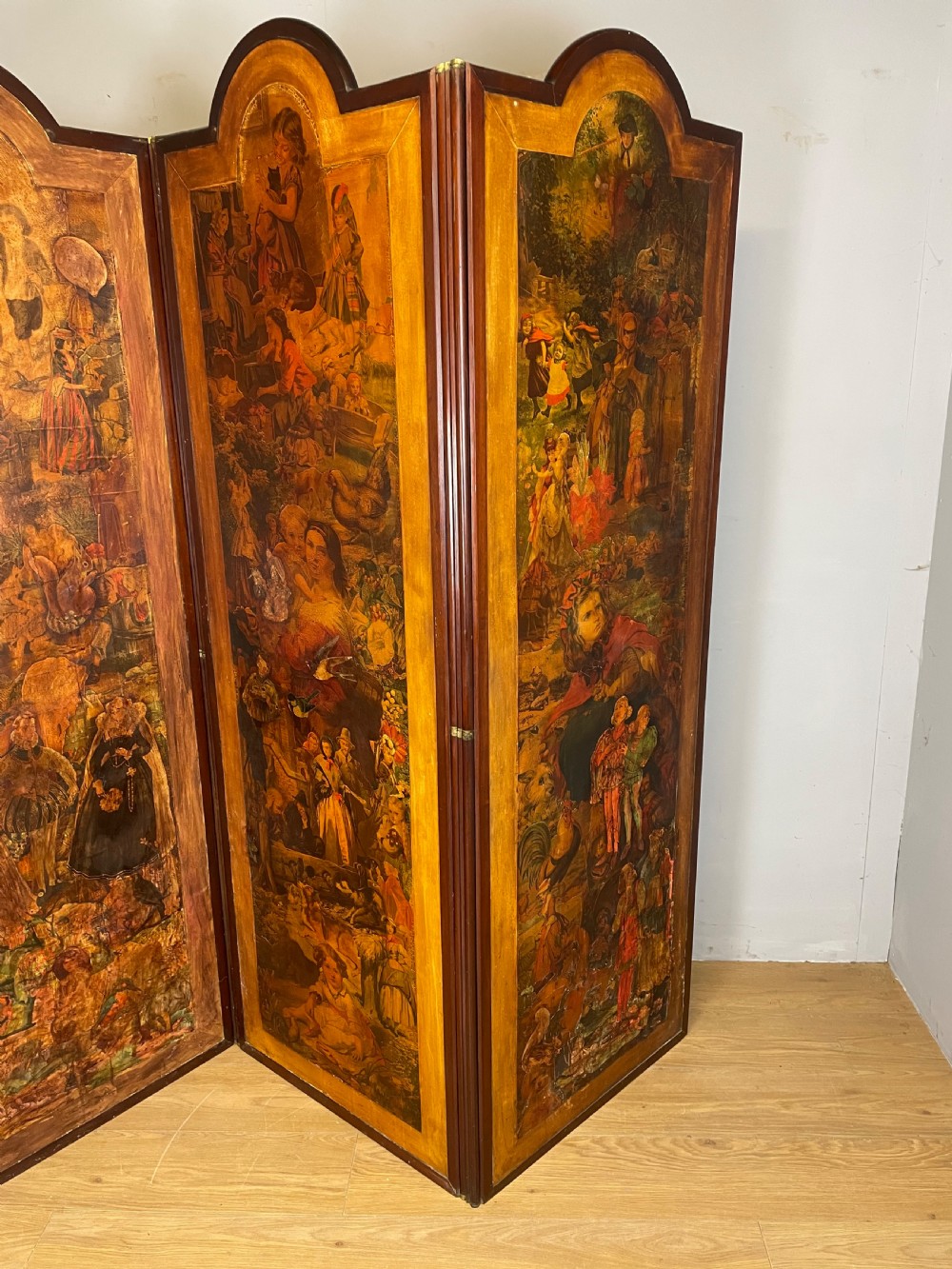 A three-panel wooden folding screen featuring dense Victorian decoupage artwork made of black and white engravings under a clear varnish finish. View XI