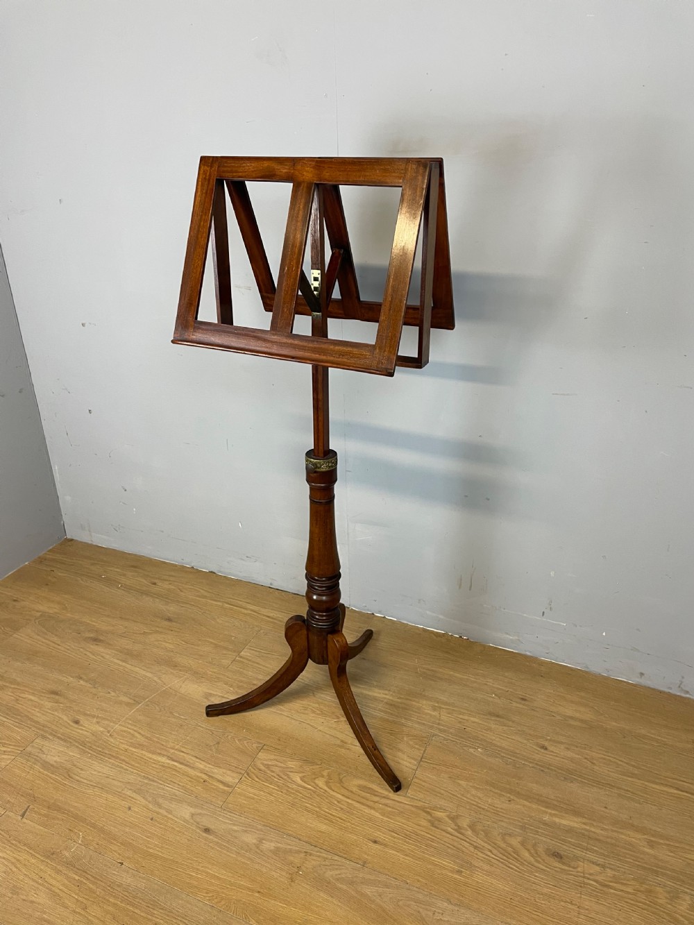 A 19th-century mahogany duet music stand featuring a double-sided adjustable reading frame on a turned column with brass fittings and tripod base.