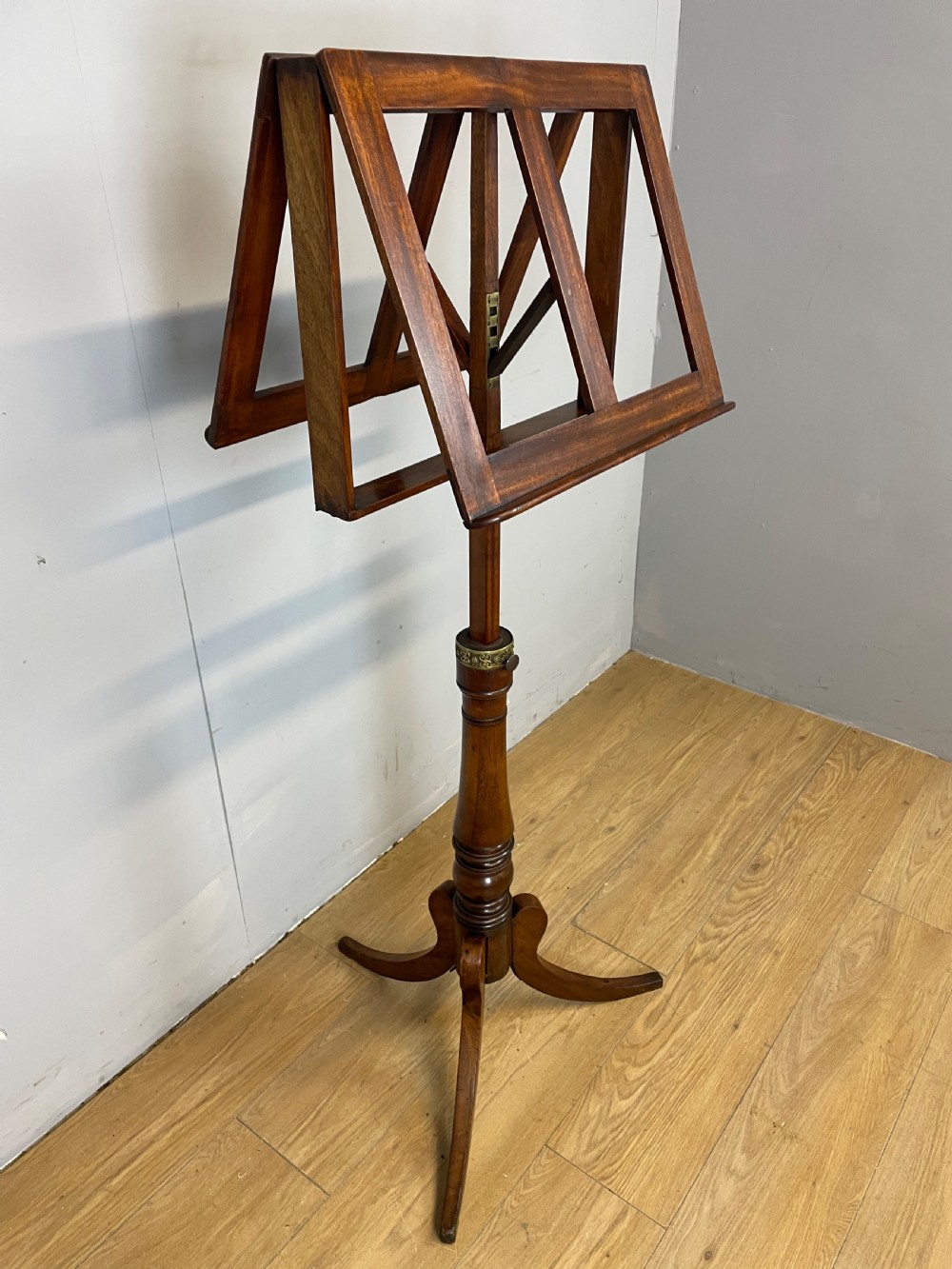 A 19th-century mahogany duet music stand featuring a double-sided adjustable reading frame on a turned column with brass fittings and tripod base. View VI