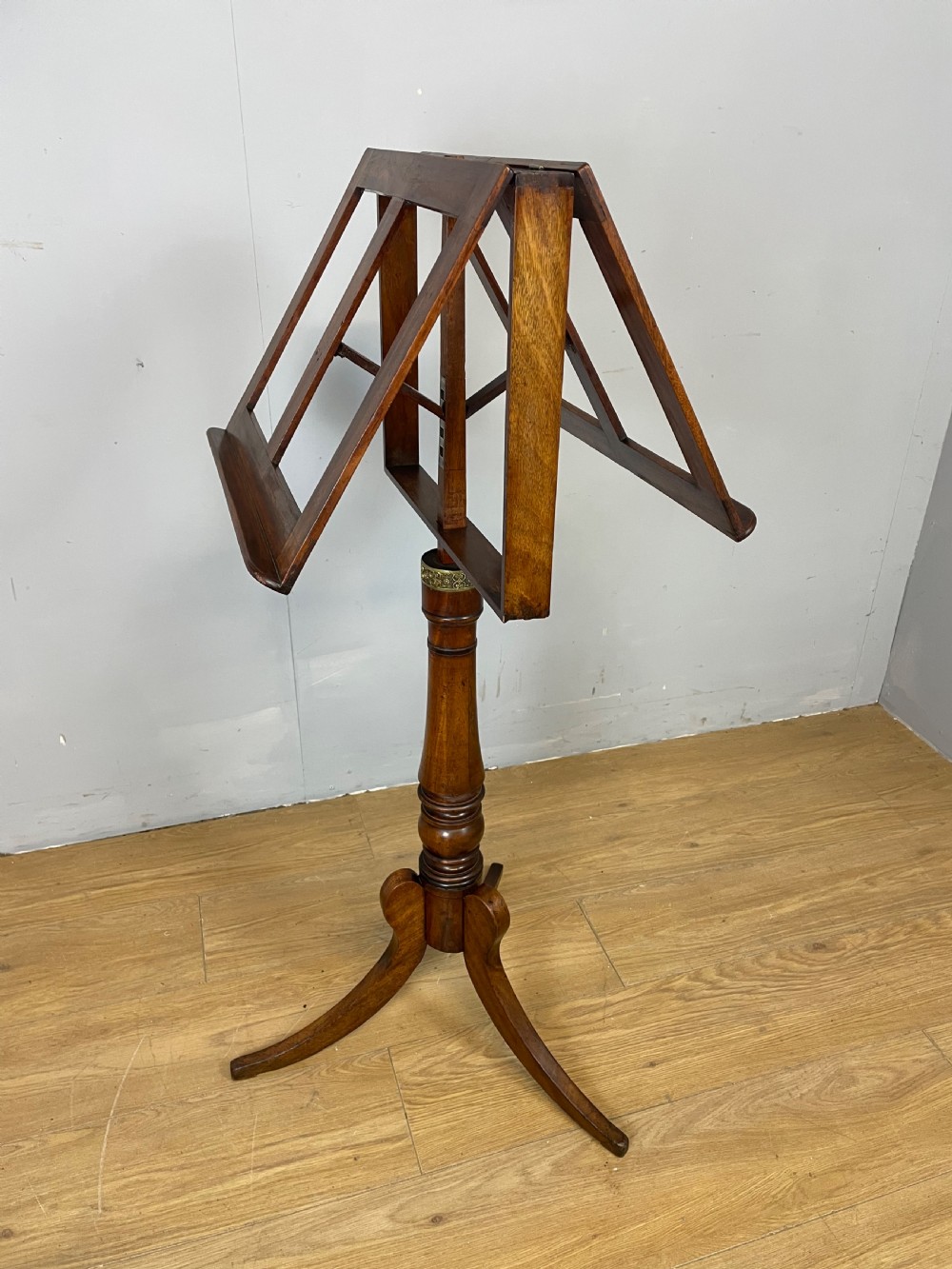 A 19th-century mahogany duet music stand featuring a double-sided adjustable reading frame on a turned column with brass fittings and tripod base. View X