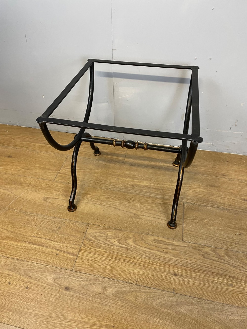 A nineteenth-century black lacquered papier-mache tray with scalloped edges and a central hand-painted floral motif resting on a black iron stand. View XII