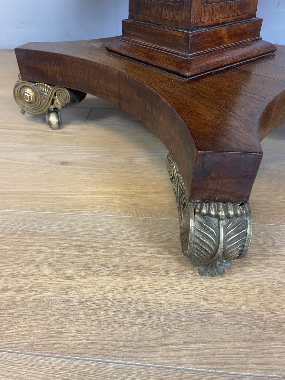 A Regency rosewood drop-leaf sofa table featuring two frieze drawers, a central column, and a quadruped platform base with decorative brass castors. View VI