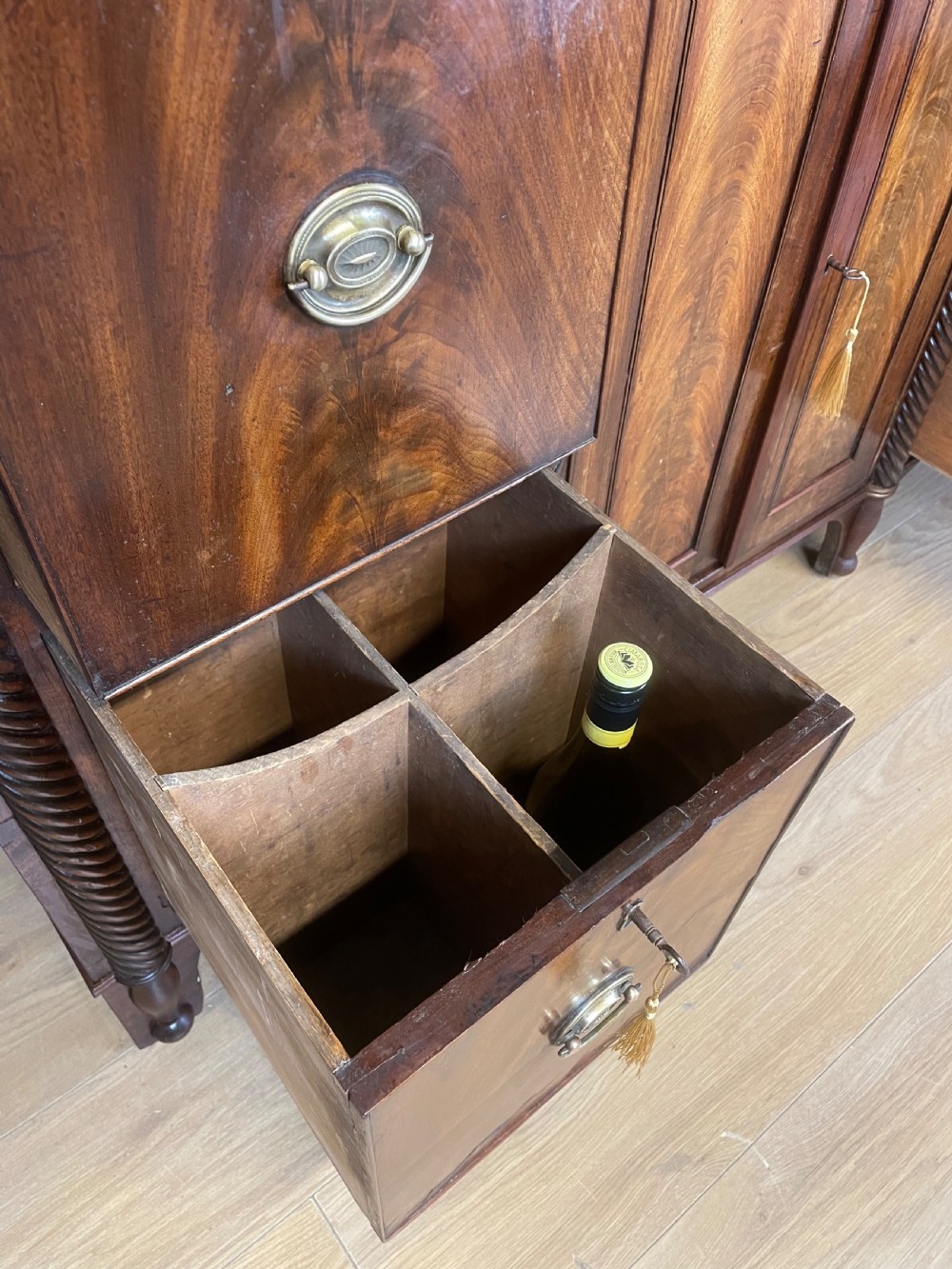 A Regency flame mahogany sideboard featuring rope-twist corner columns, multiple drawers with brass ring handles, and central cupboard doors. View IX