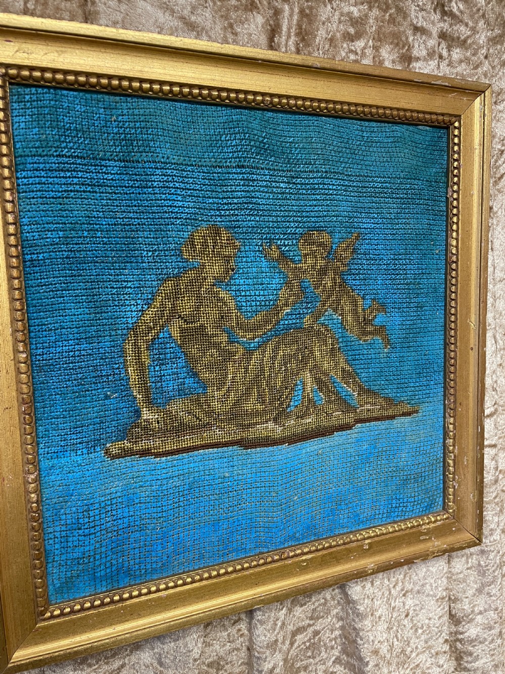 A pair of gilt-framed 19th-century needlework pictures featuring classical figures stitched in gold thread against a blue backdrop. View VI