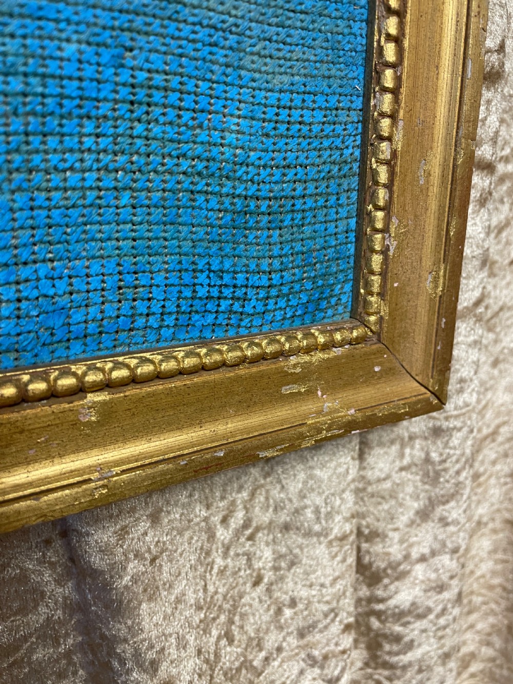 A pair of gilt-framed 19th-century needlework pictures featuring classical figures stitched in gold thread against a blue backdrop. View VII