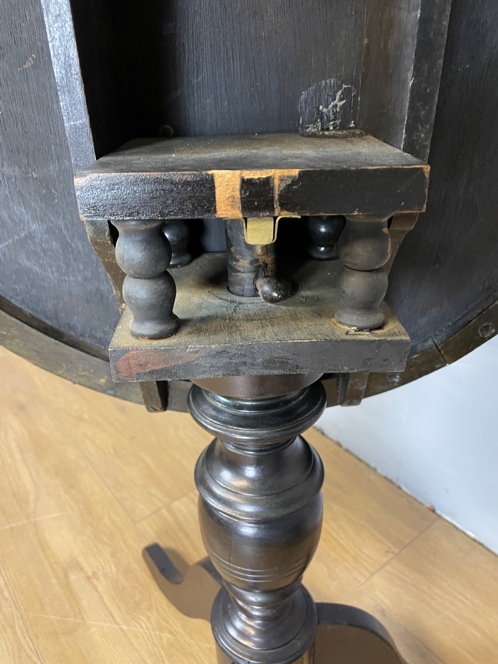 An Edwardian black lacquered circular tripod table decorated with mother-of-pearl figurative inlays and gilt floral borders. View VI