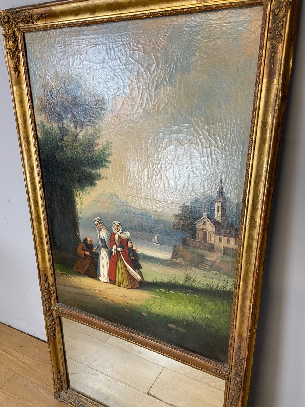 A tall 19th-century gilt-framed pier mirror featuring an upper integral landscape oil painting above a rectangular reflective mirror panel. View IV
