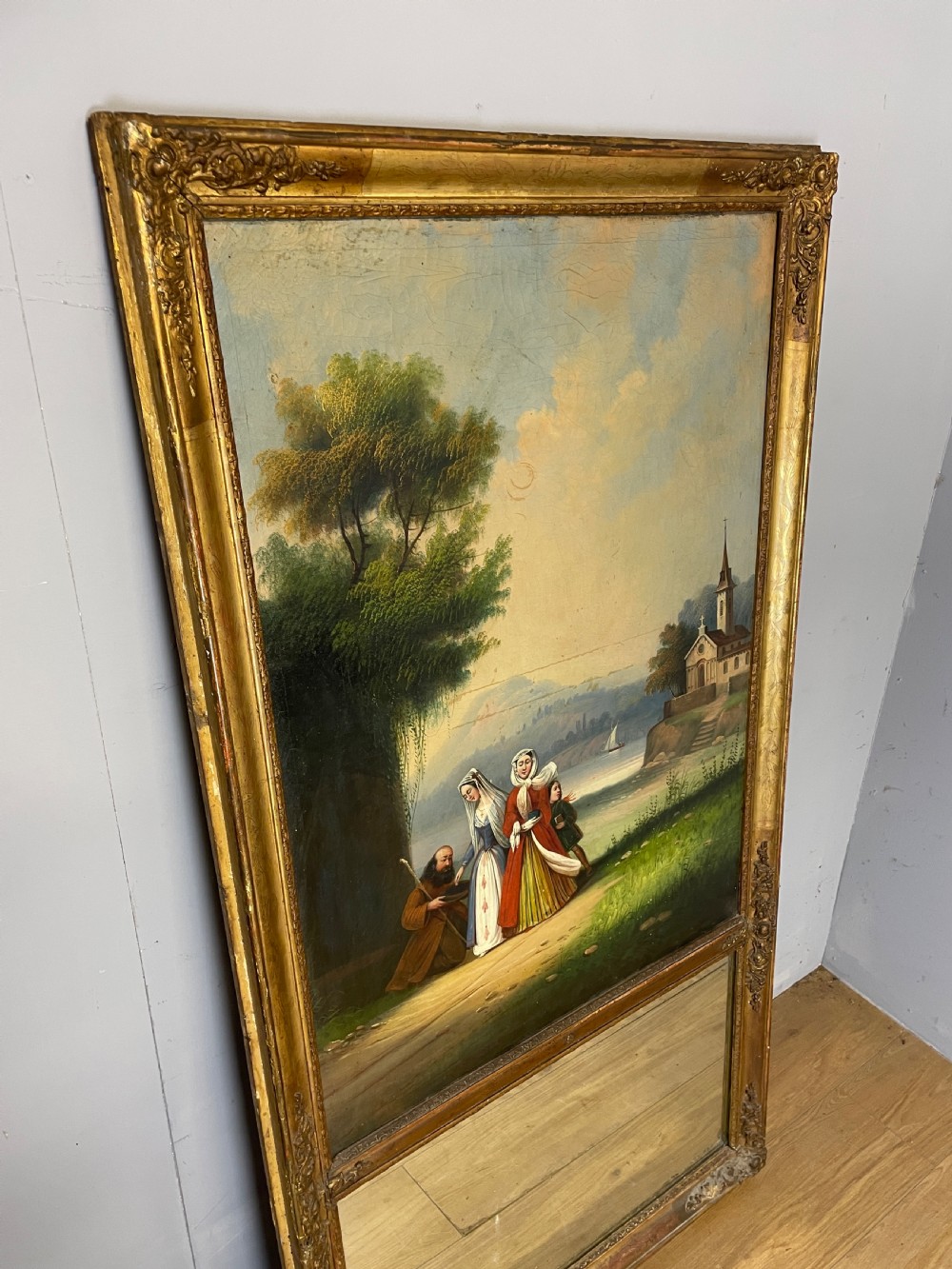A tall 19th-century gilt-framed pier mirror featuring an upper integral landscape oil painting above a rectangular reflective mirror panel. View V