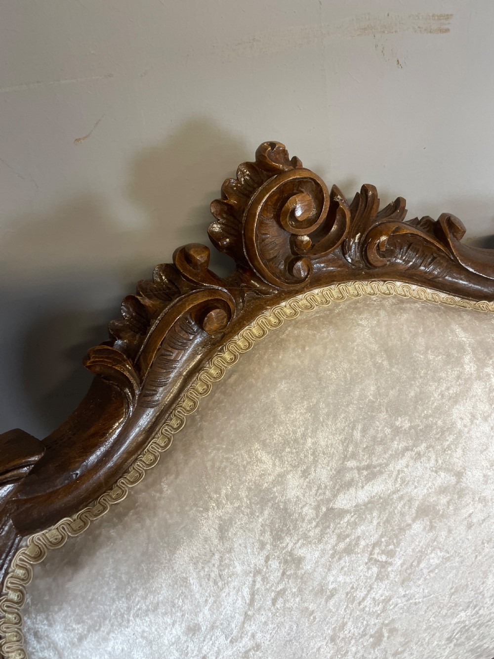 A pair of French carved walnut open armchairs upholstered in cream crushed fabric with cabriole legs and ornate cresting. View V