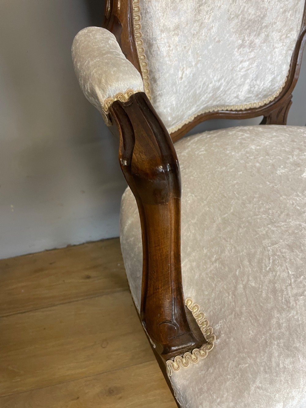 A pair of French carved walnut open armchairs upholstered in cream crushed fabric with cabriole legs and ornate cresting. View VI