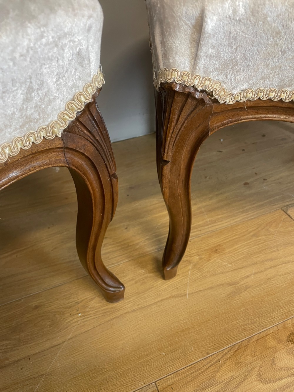 A pair of French carved walnut open armchairs upholstered in cream crushed fabric with cabriole legs and ornate cresting. View VII