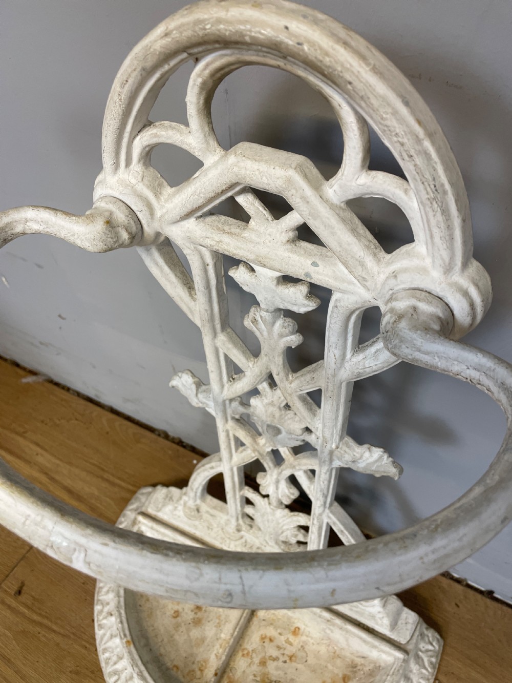 A white painted 19th-century Victorian cast iron stick stand featuring intricate Gothic tracery, an upper retaining hoop, and a divided drip tray base. View IV