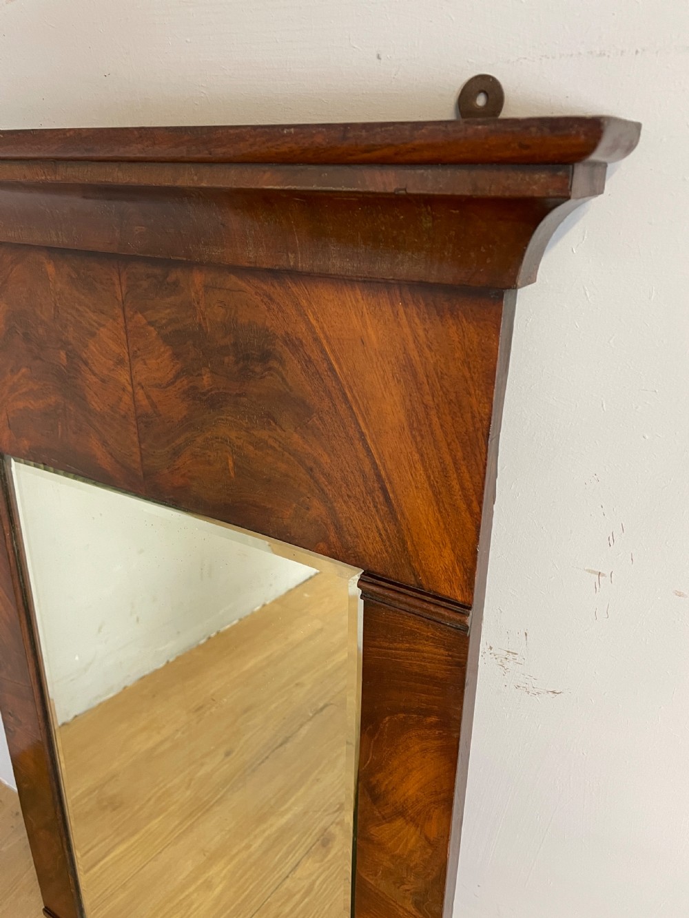 A nineteenth-century Biedermeier rectangular wall mirror featuring book-matched flame mahogany veneers and a stepped architectural top moulding. View II