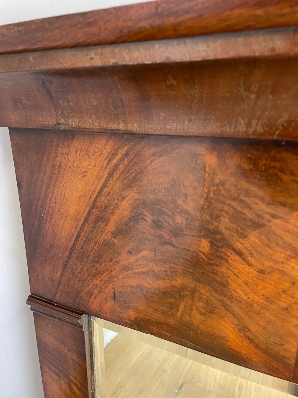 A nineteenth-century Biedermeier rectangular wall mirror featuring book-matched flame mahogany veneers and a stepped architectural top moulding. View IV