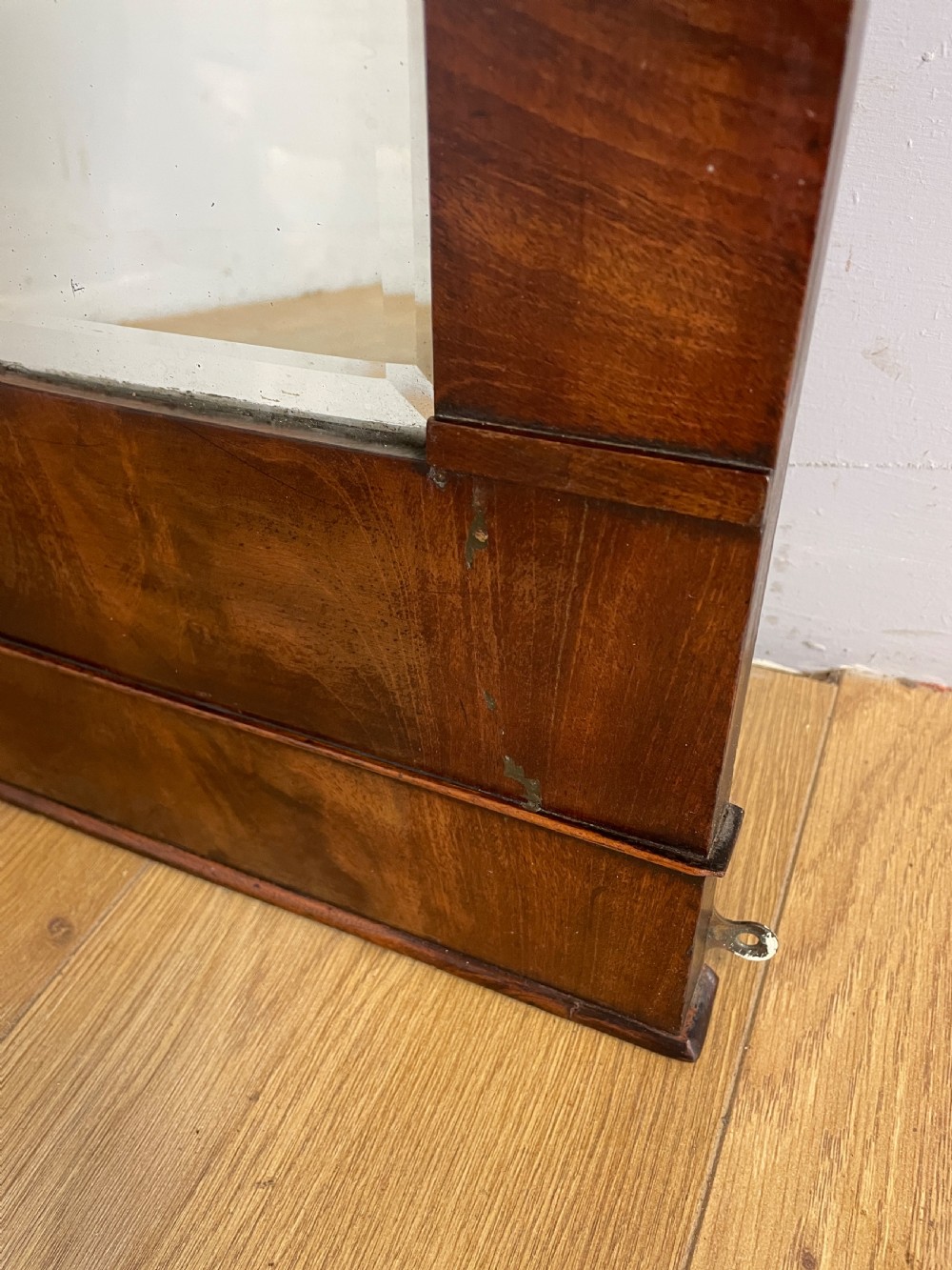 A nineteenth-century Biedermeier rectangular wall mirror featuring book-matched flame mahogany veneers and a stepped architectural top moulding. View V