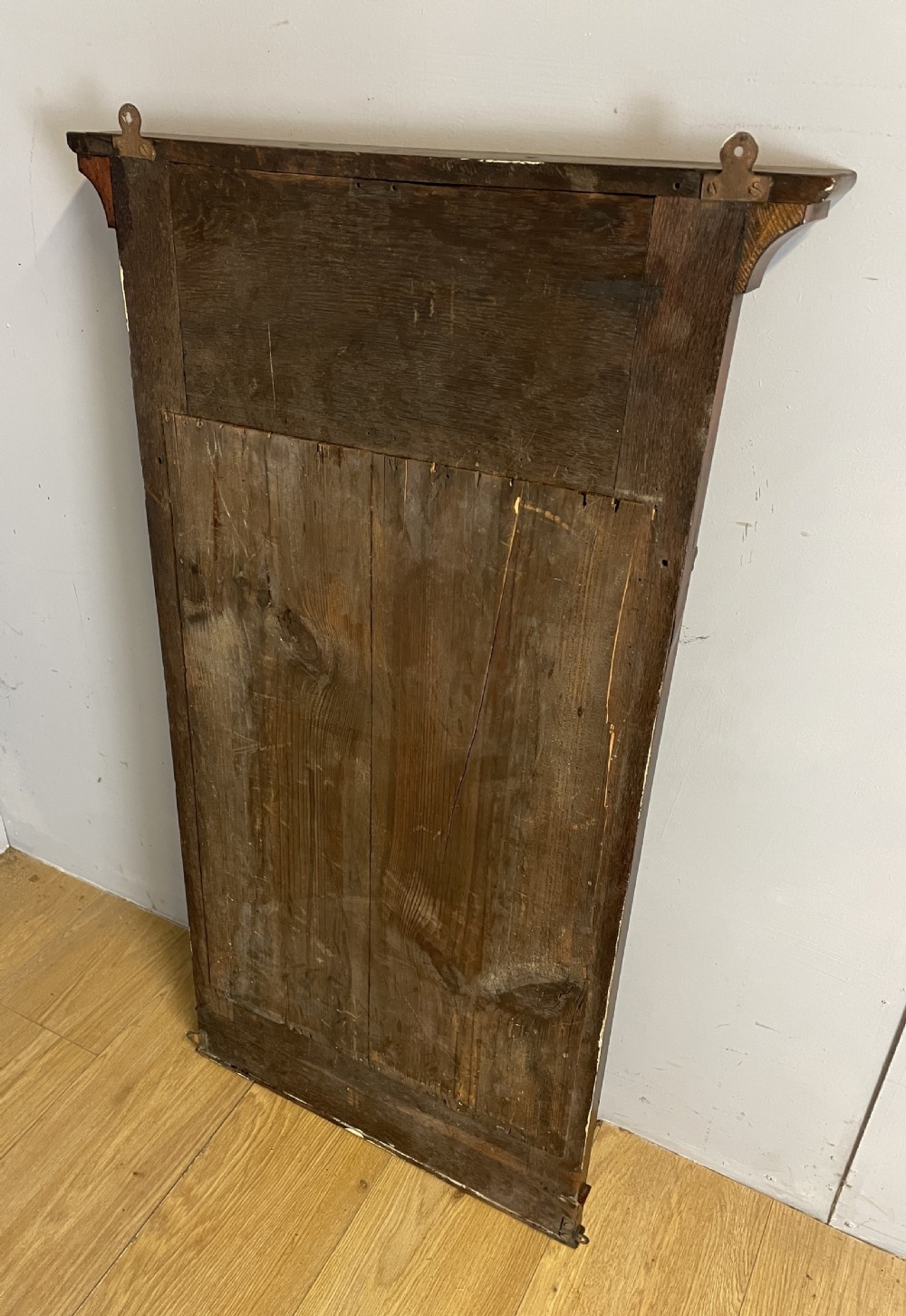 A nineteenth-century Biedermeier rectangular wall mirror featuring book-matched flame mahogany veneers and a stepped architectural top moulding. View VII