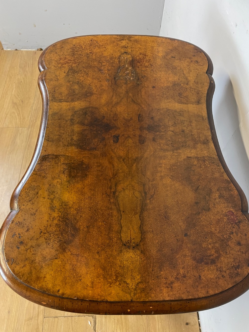 A Victorian burr walnut work table shown with its hinged lid open, revealing intricate fretwork covers, internal compartments, and carved turned legs. View V