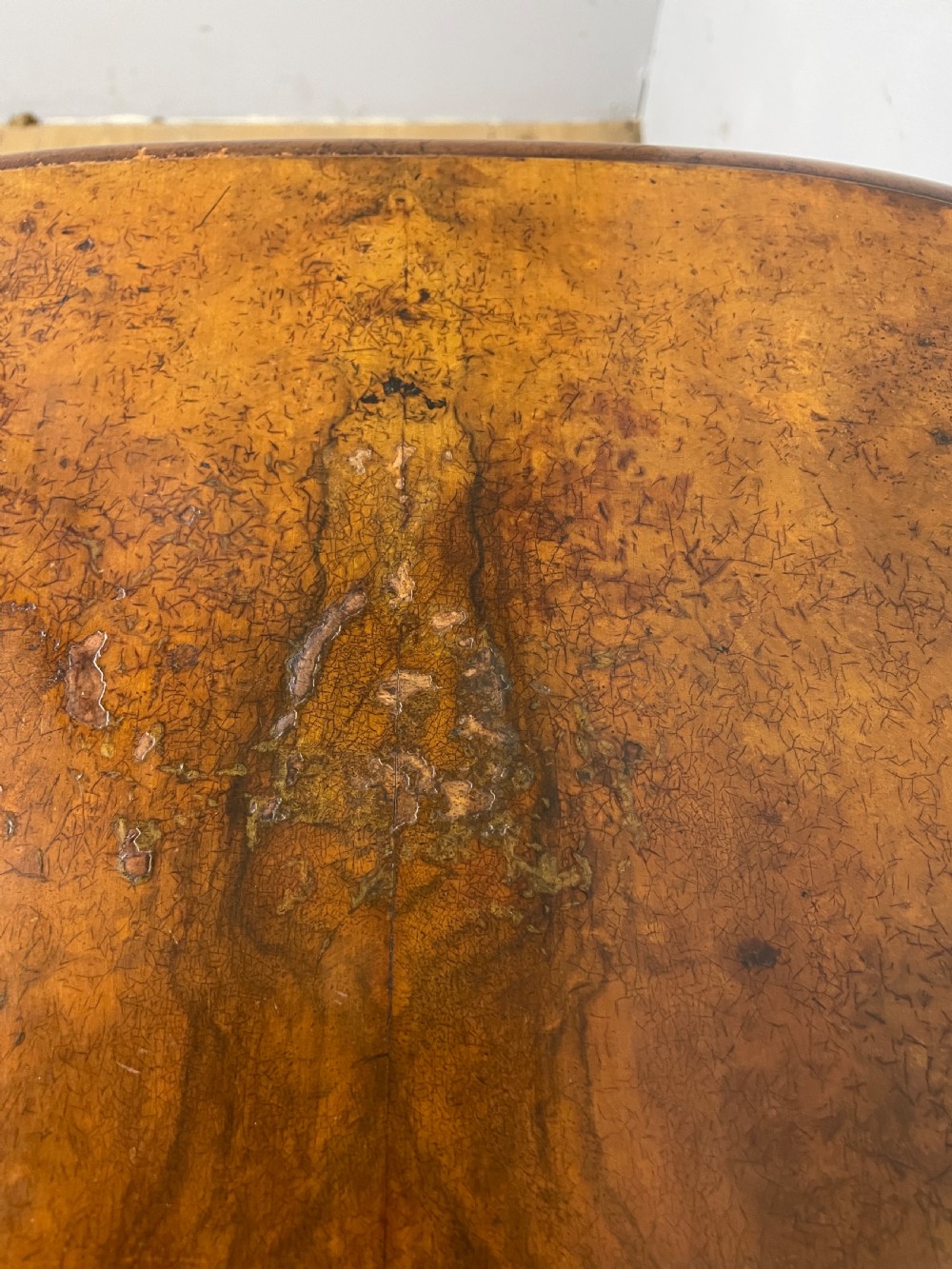 A Victorian burr walnut work table shown with its hinged lid open, revealing intricate fretwork covers, internal compartments, and carved turned legs. View VI