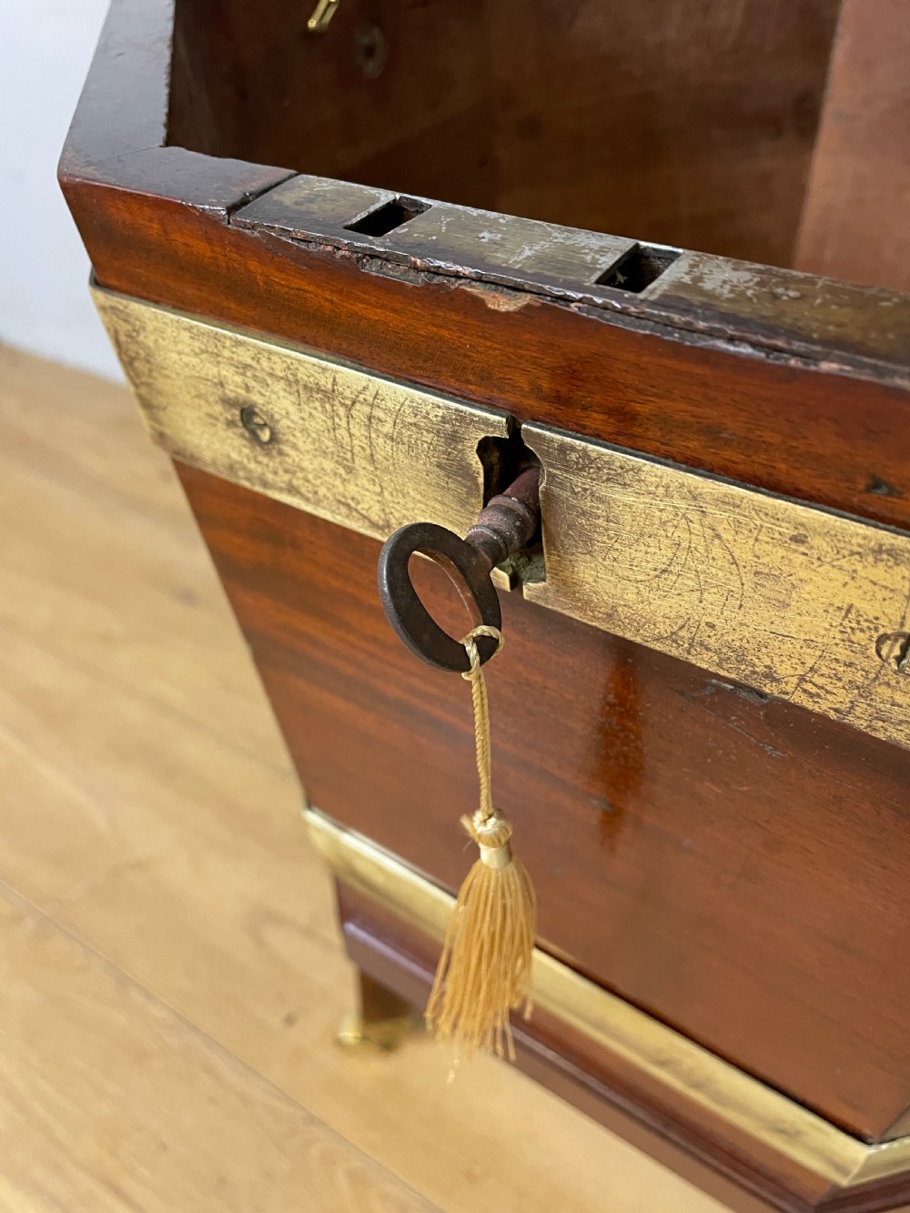An octagonal Georgian mahogany cellarette bound with brass bands and supported by four square tapered legs on brass castors. View VI