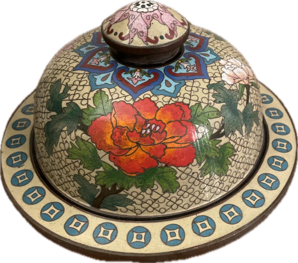 An antique cloisonne covered vase with a cream patterned background decorated with pink and red peony blossoms, green leaves, and a domed lid. View VI