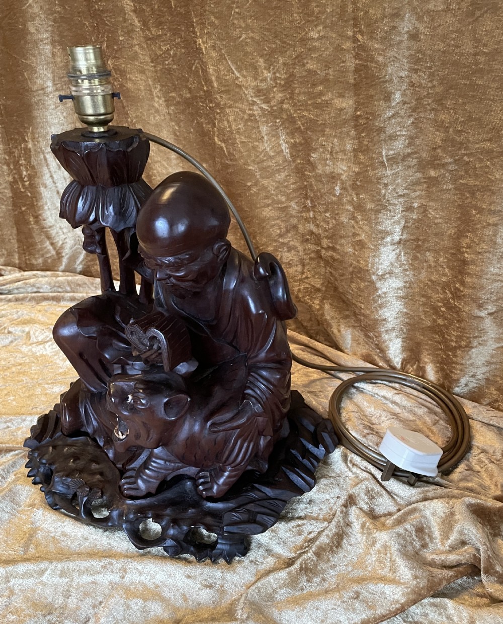 Late nineteenth-century Chinese carved dark wood table lamp depicting a seated scholar figure reading beside a tiger on a carved base with brass bulb holder. View VI